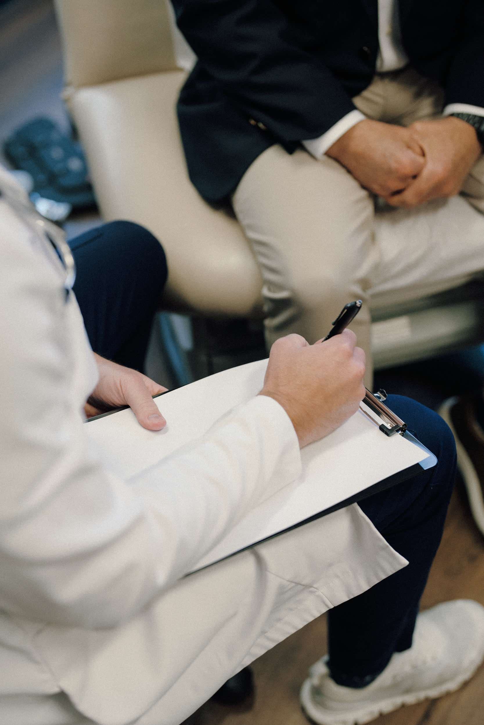 Physician taking notes during a patient consultation